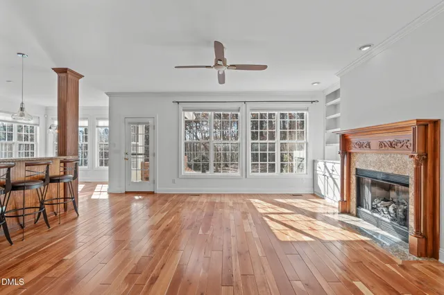 wooden floor fireplace and windows in an empty room