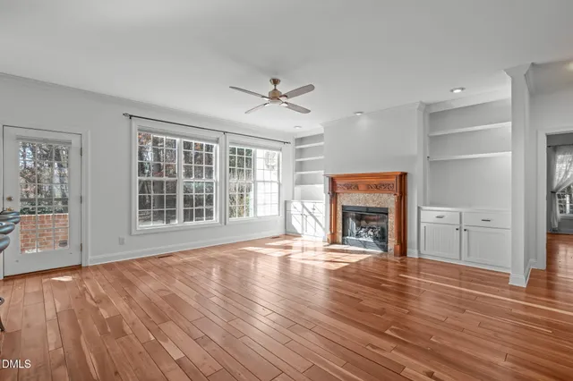 a view of an empty room with window and fire place