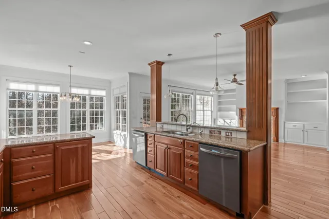 a kitchen with granite countertop a sink stove and cabinets