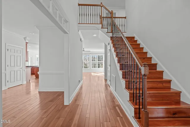 a view of a room with wooden floor staircase and a chandelier