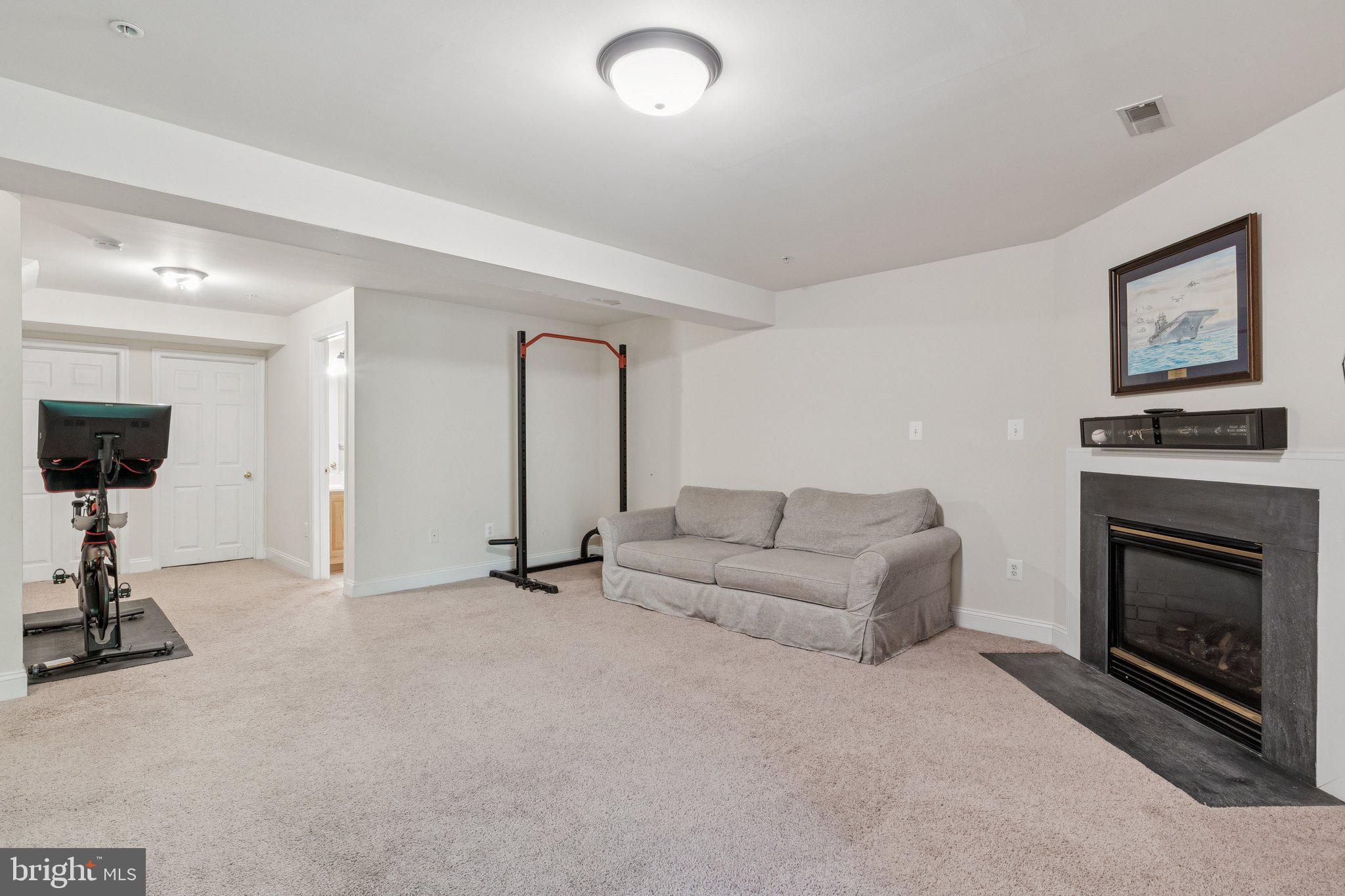 856 Stonehurst Drive Annapolis, MD 21409 - Photo 12 of 31 a living room with furniture a fireplace and a flat screen tv