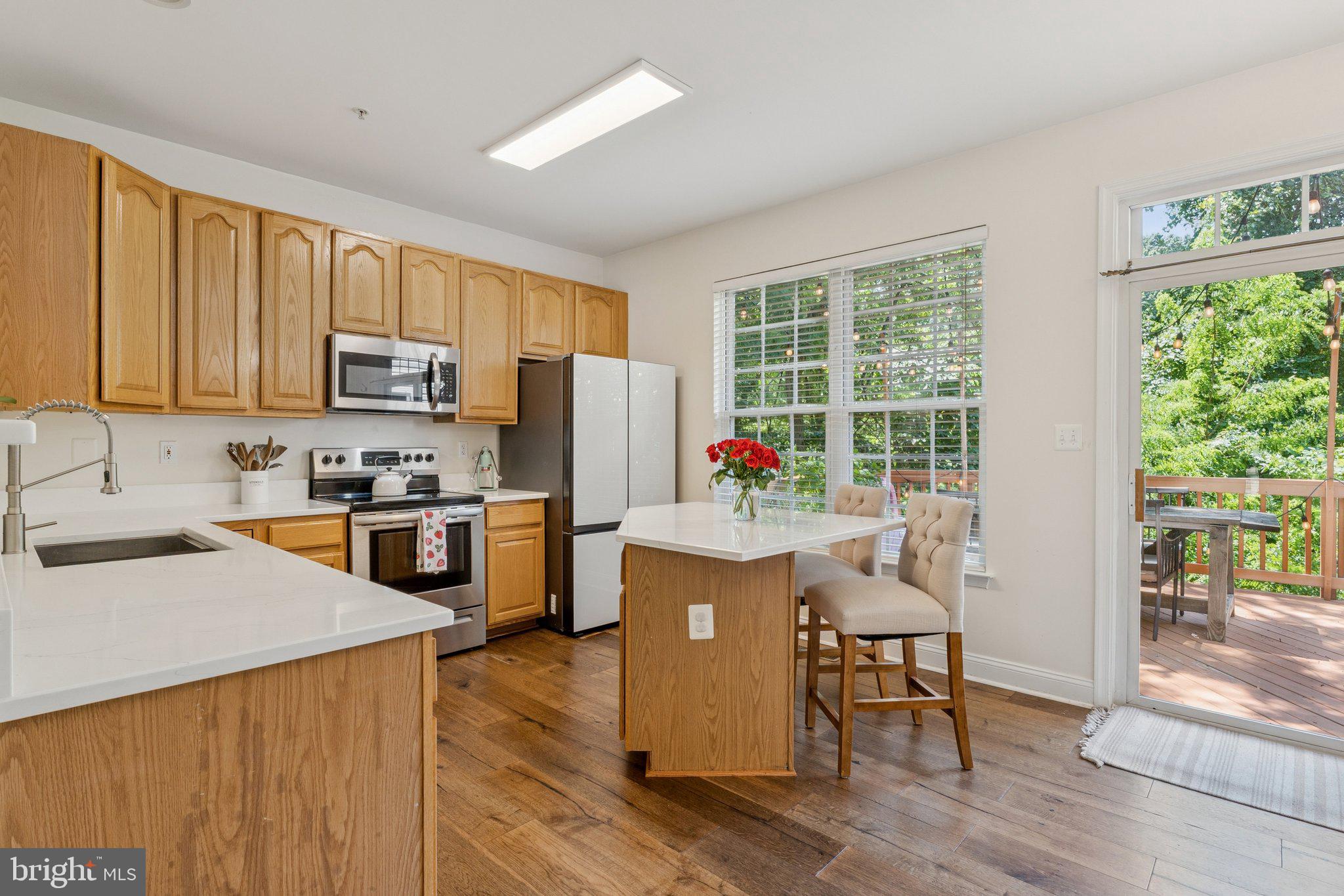 856 Stonehurst Drive Annapolis, MD 21409 - Photo 7 of 31 a kitchen with granite countertop a stove top oven a sink dishwasher a dining table and chairs with wooden floor