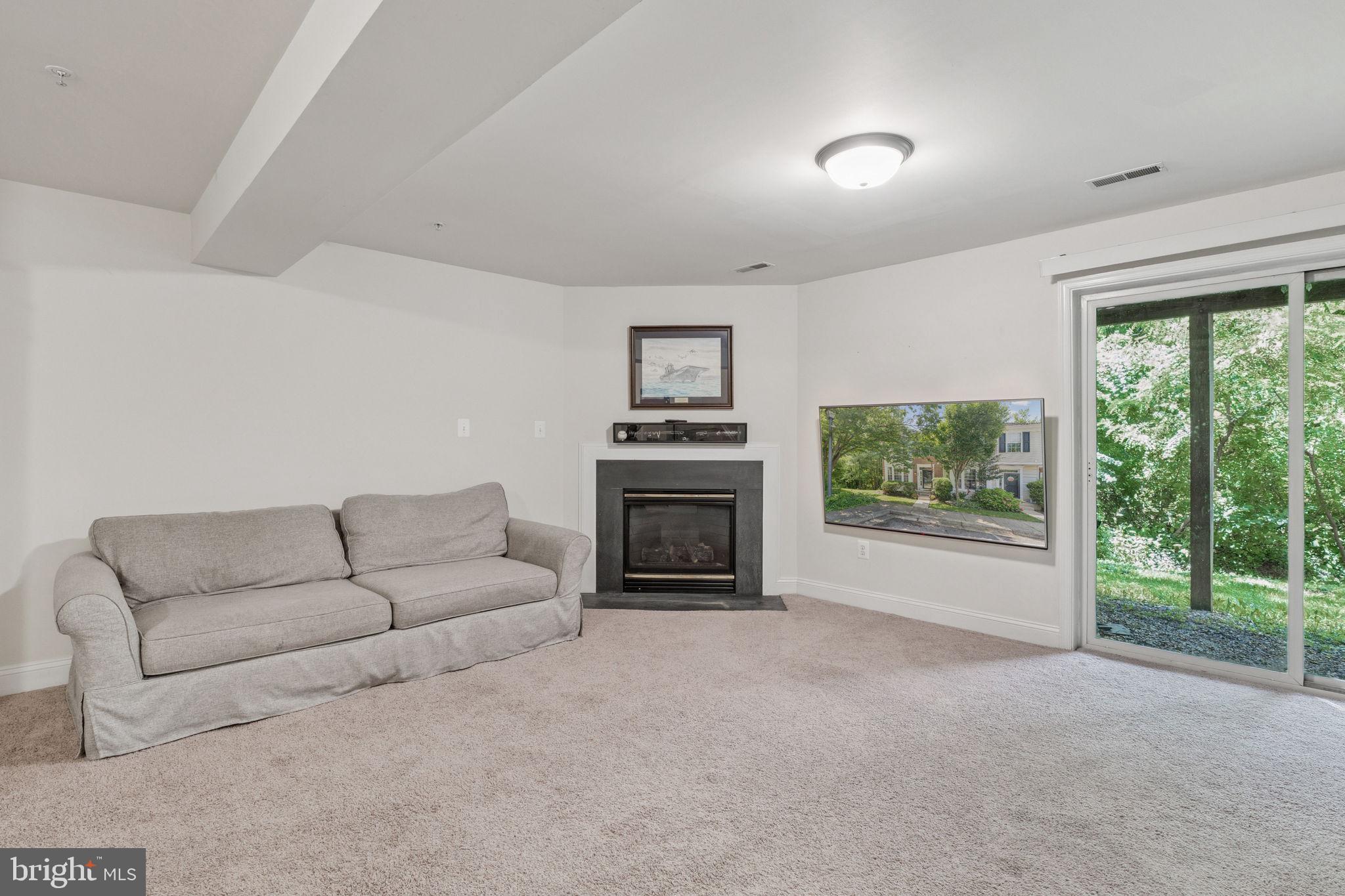 856 Stonehurst Drive Annapolis, MD 21409 - Photo 10 of 31 a living room with furniture a fireplace and a flat screen tv