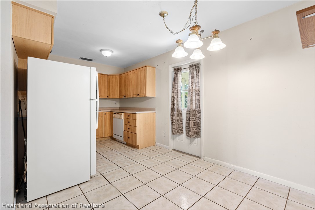 3303 Lakewood Road Sebring, FL 33875 - Photo 24 of 34 a kitchen with stainless steel appliances a refrigerator and a chandelier