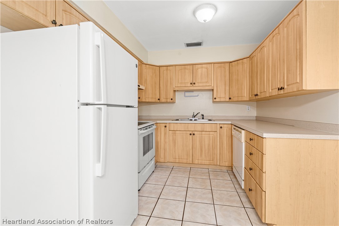3303 Lakewood Road Sebring, FL 33875 - Photo 26 of 34 a kitchen with a white cabinets and white appliances