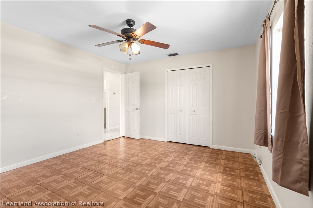 3303 Lakewood Road Sebring, FL 33875 - Photo 32 of 34 a view of a big room with wooden floor and a chandelier fan