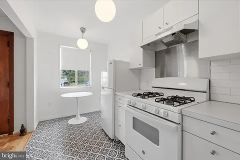 a kitchen with granite countertop a sink stove and cabinets