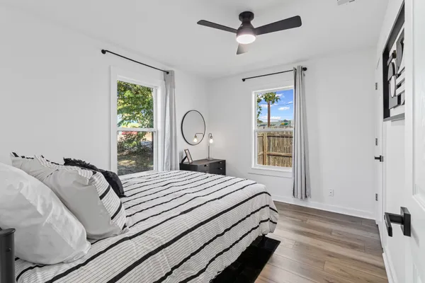 a bedroom with a bed wooden floor and window
