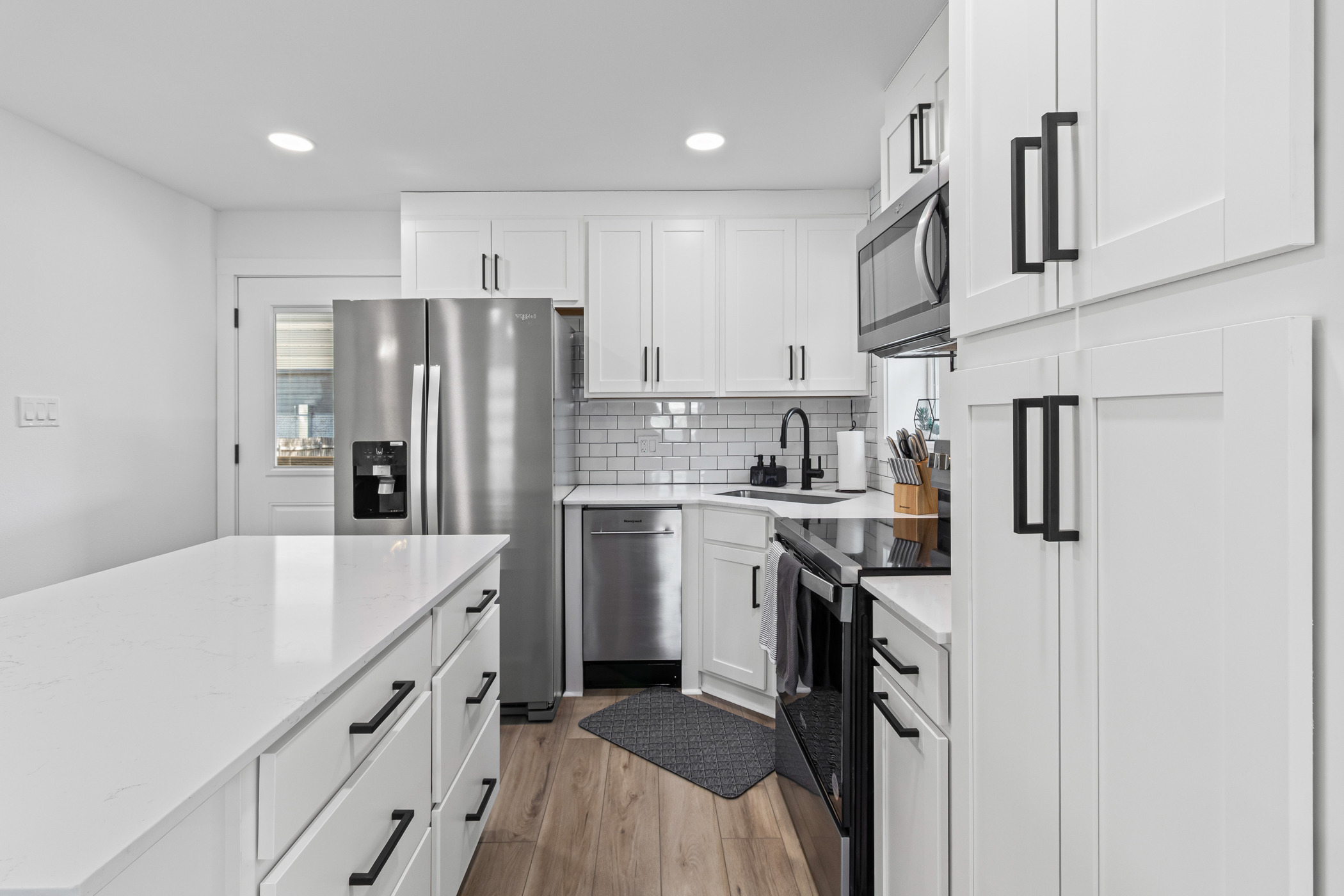 901 North Church Street Georgetown, TX 78626 - Photo 6 of 32 Kitchen featuring stainless steel appliances, white cabinetry, recessed lighting, light wood-style flooring, and backsplash