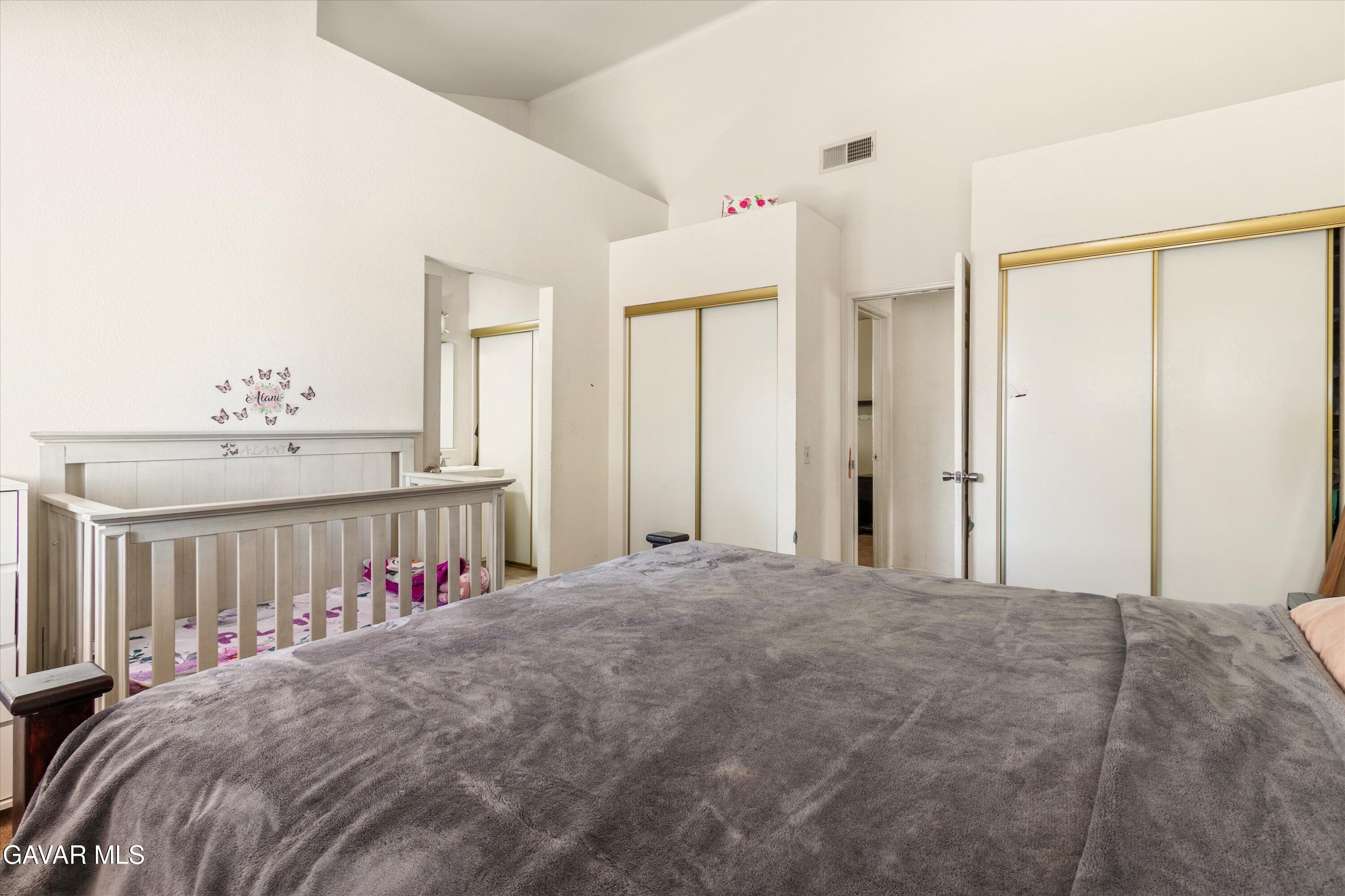 43653 Serenity Court, Unit 1 Lancaster, CA 93535 - Photo 15 of 18 a bed room with a bed and a large mirror