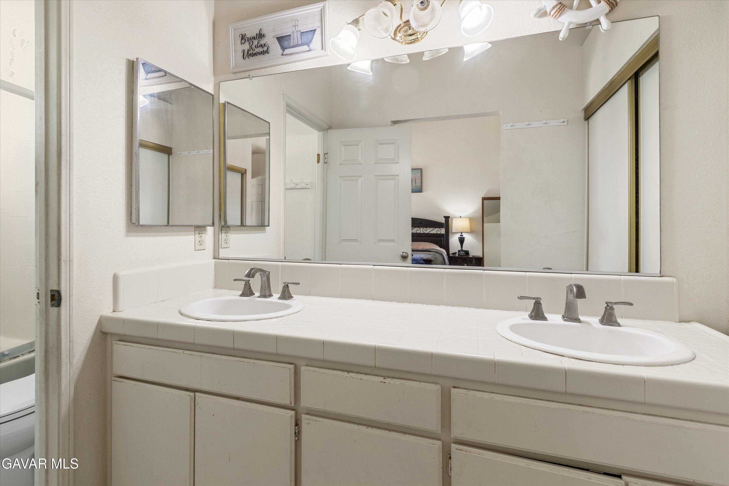 43653 Serenity Court, Unit 1 Lancaster, CA 93535 - Photo 17 of 18 a bathroom with a sink and a mirror