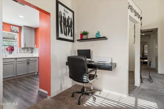 a view of a workspace with furniture and a window