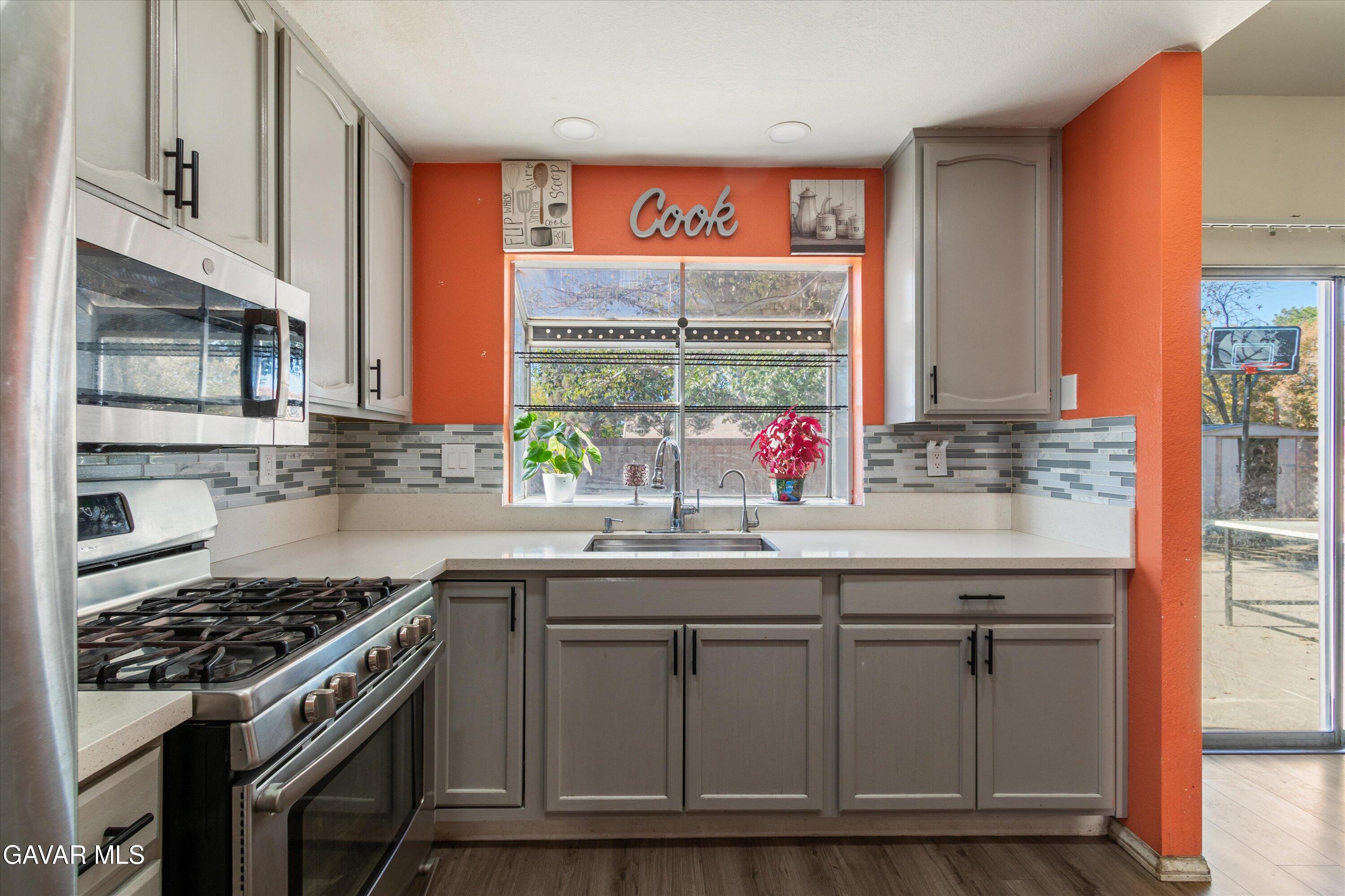 43653 Serenity Court, Unit 1 Lancaster, CA 93535 - Photo 7 of 18 a kitchen with granite countertop a sink and a stove
