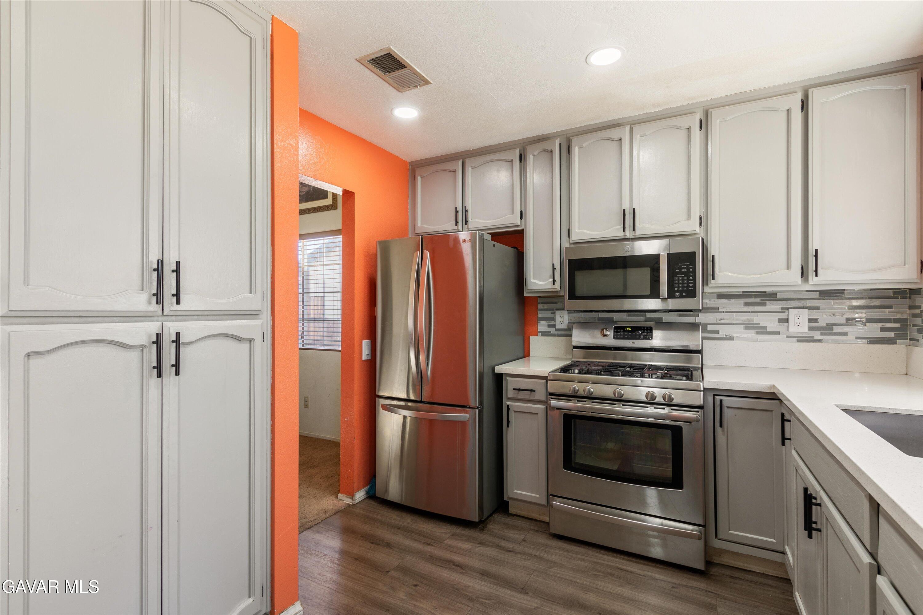 43653 Serenity Court, Unit 1 Lancaster, CA 93535 - Photo 8 of 18 a kitchen with stainless steel appliances a stove microwave and refrigerator