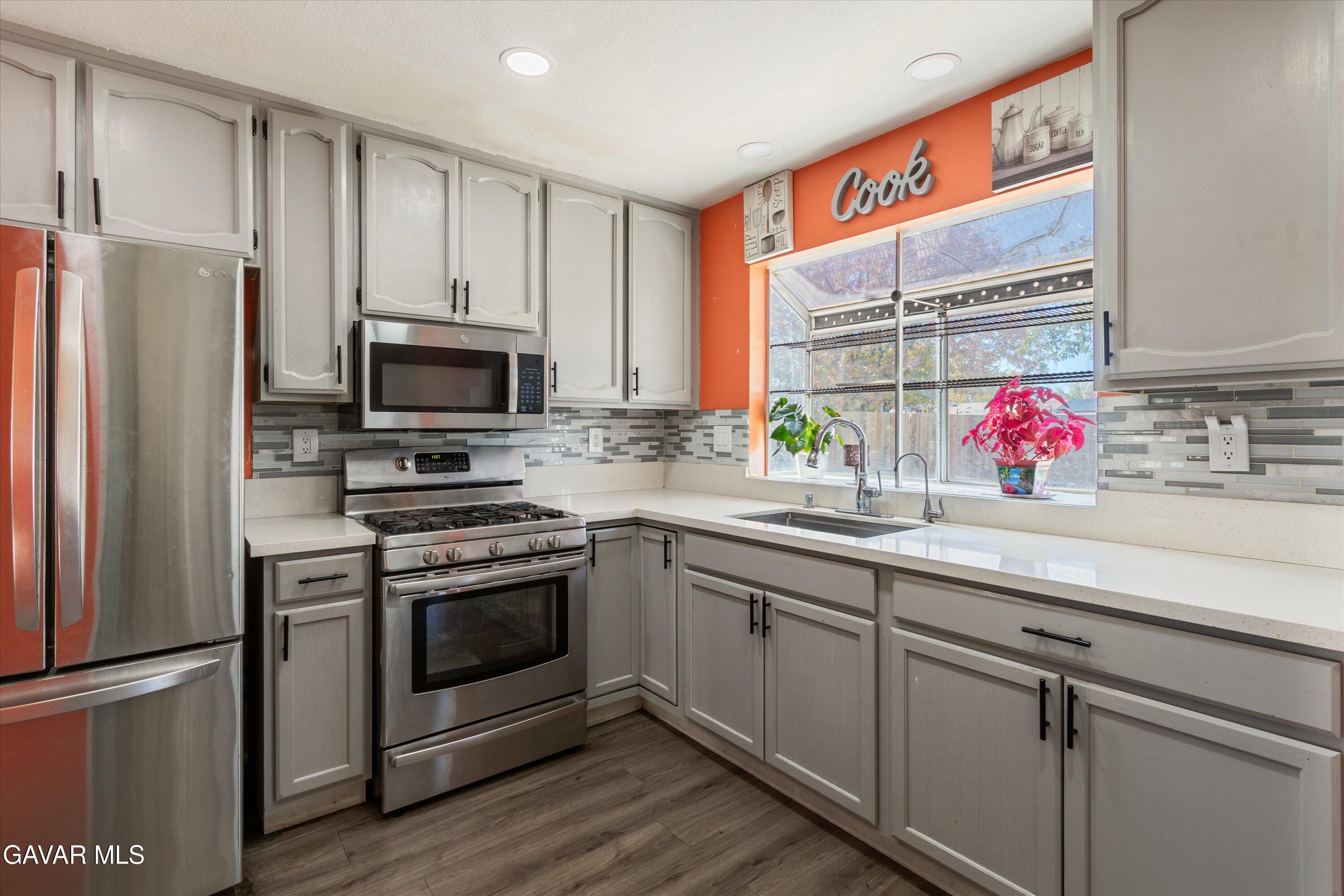 43653 Serenity Court, Unit 1 Lancaster, CA 93535 - Photo 9 of 18 a kitchen with stainless steel appliances a sink cabinets and a window