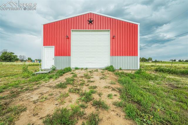 12550 Smith Road Peyton, CO 80831 - Photo 9 of 35 View of outdoor structure featuring a garage
