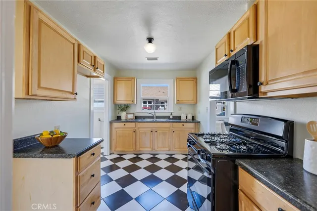 a kitchen with stainless steel appliances a stove a sink and a microwave