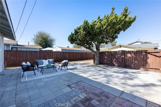 a roof deck with a table and chairs and potted plants