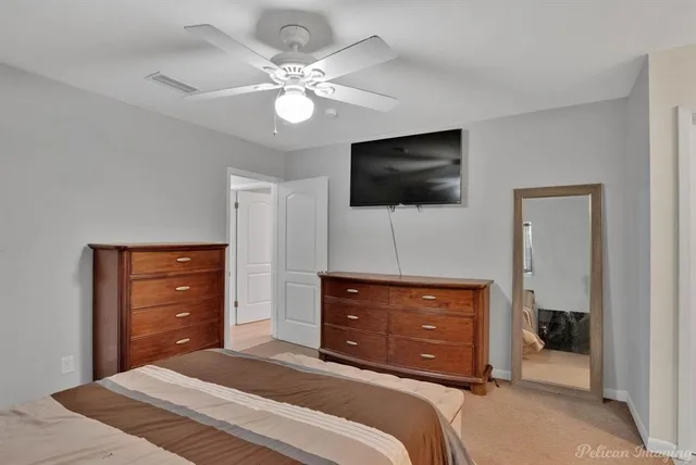 a bedroom with a bed and a flat tv screen on dresser