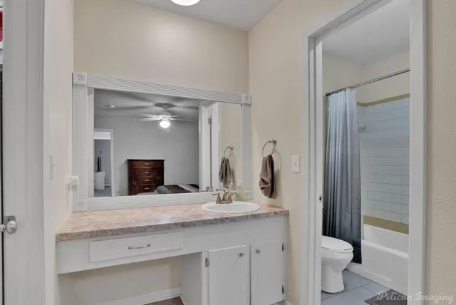 a bathroom with a granite countertop sink a toilet and a mirror