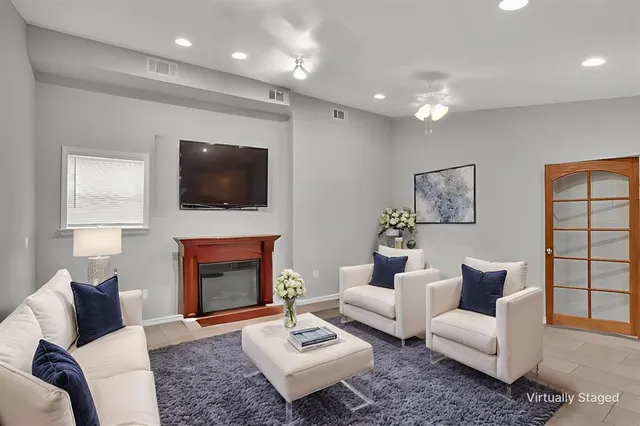 a living room with furniture a fireplace and a flat screen tv