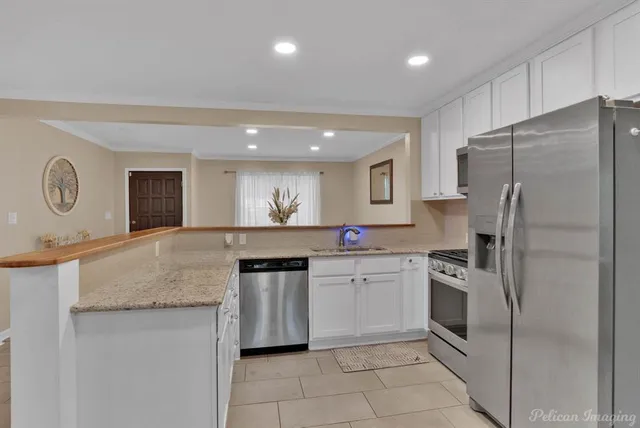 a kitchen with stainless steel appliances granite countertop a refrigerator sink and stove