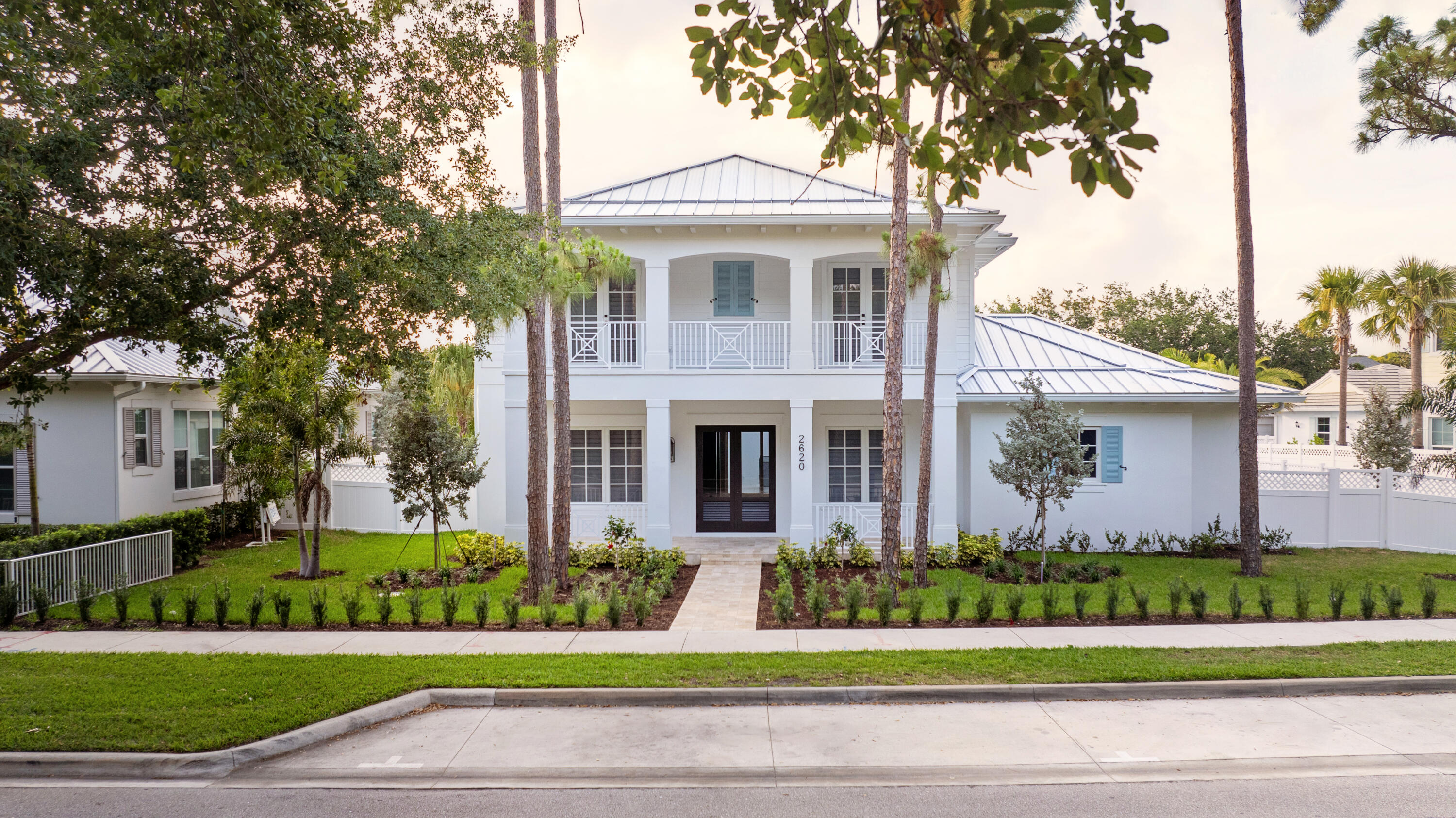 a front view of a house with a garden and plants