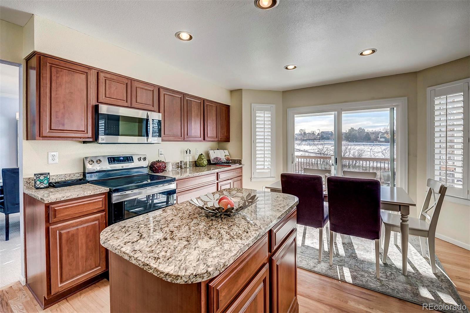 9847 Spring Hill Lane Highlands Ranch, CO 80129 - Photo 13 of 33 a kitchen with a stove a sink a microwave a dining table and chairs