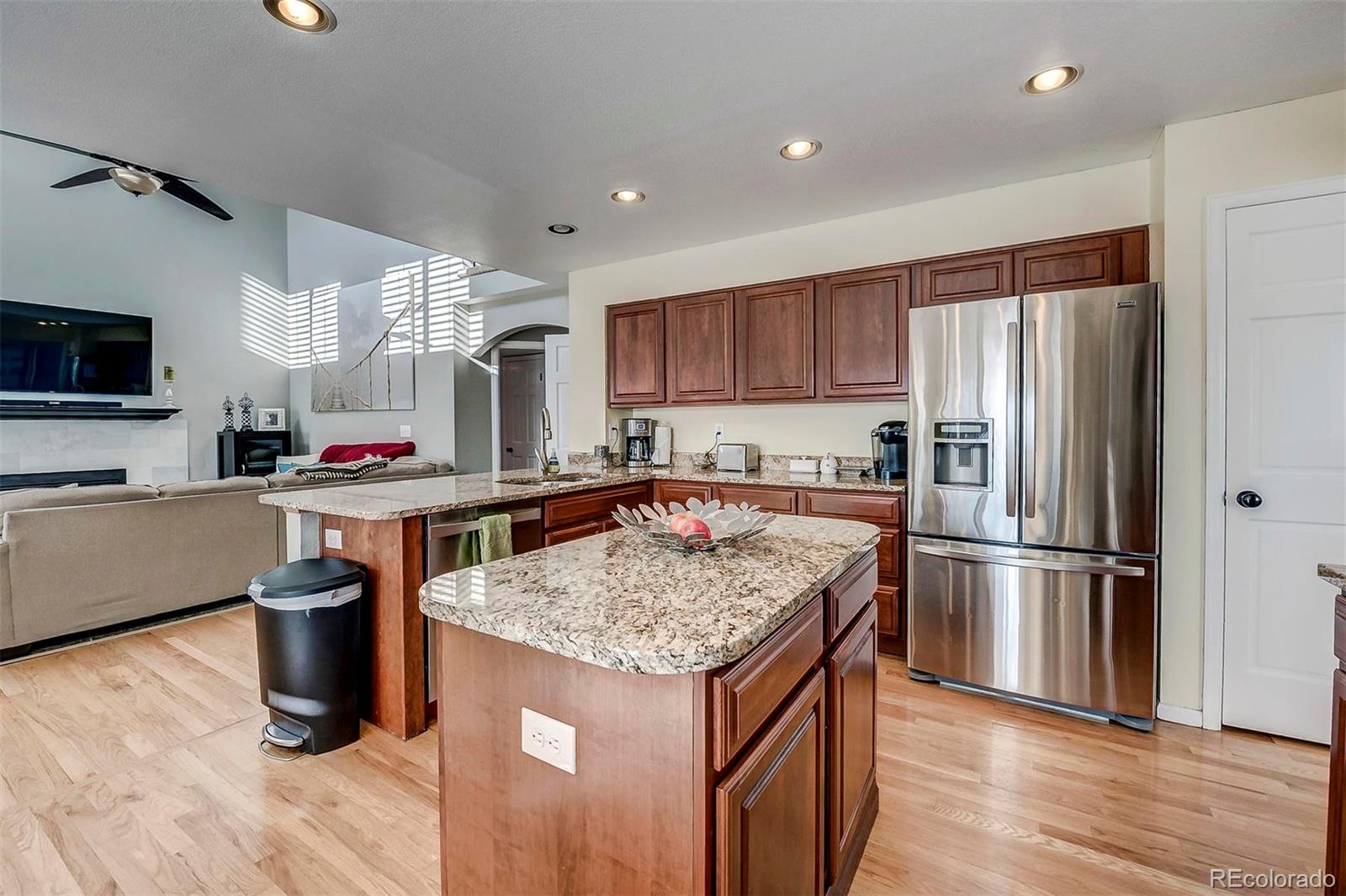 9847 Spring Hill Lane Highlands Ranch, CO 80129 - Photo 16 of 33 a kitchen with stainless steel appliances granite countertop a sink stove and refrigerator