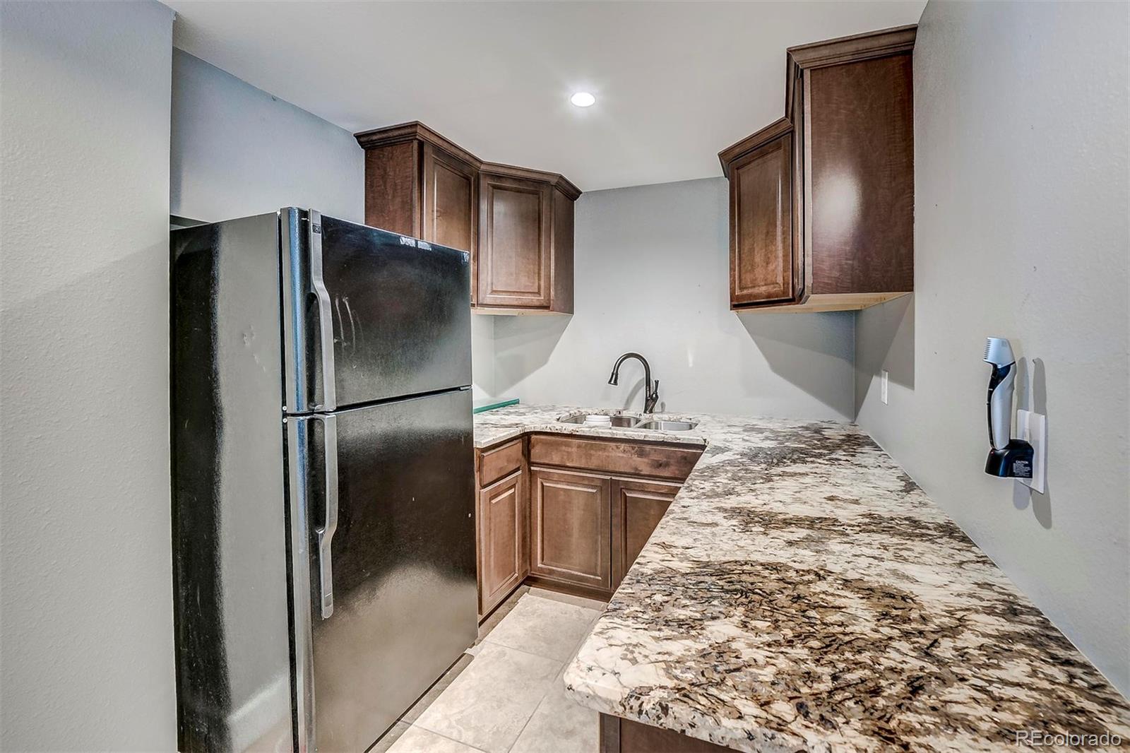 9847 Spring Hill Lane Highlands Ranch, CO 80129 - Photo 25 of 33 a kitchen with stainless steel appliances granite countertop a refrigerator and a sink