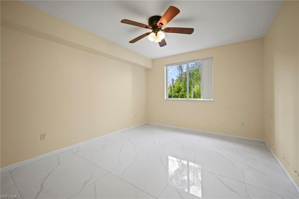 1820 Florida Club Circle, Unit 2103 Naples, FL 34112 - Photo 13 of 22 an empty room with windows and ceiling fan