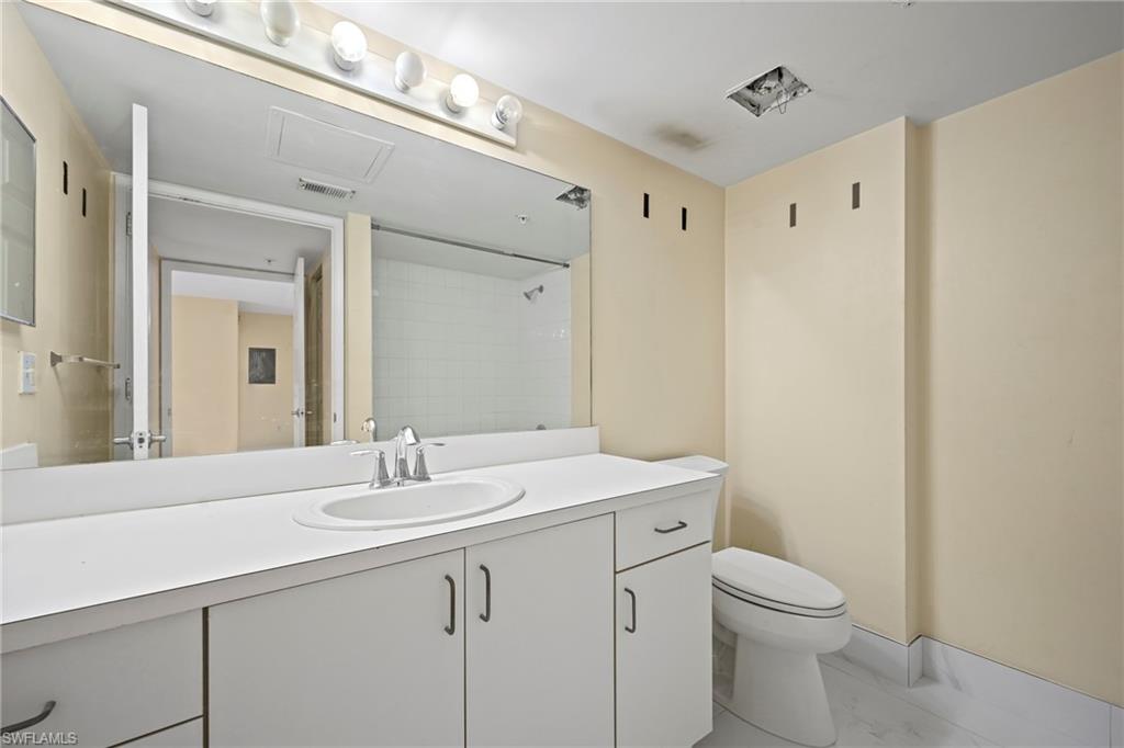 1820 Florida Club Circle, Unit 2103 Naples, FL 34112 - Photo 14 of 22 a bathroom with a sink a toilet a large mirror and vanity