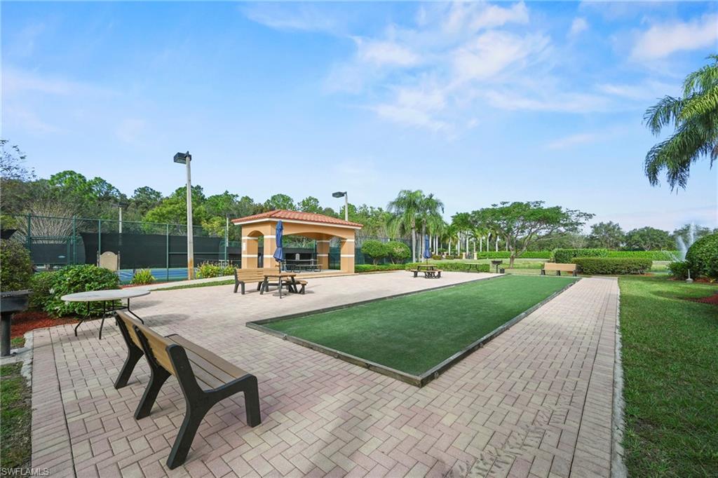 1820 Florida Club Circle, Unit 2103 Naples, FL 34112 - Photo 22 of 22 a view of a patio with a table and chairs under an umbrella