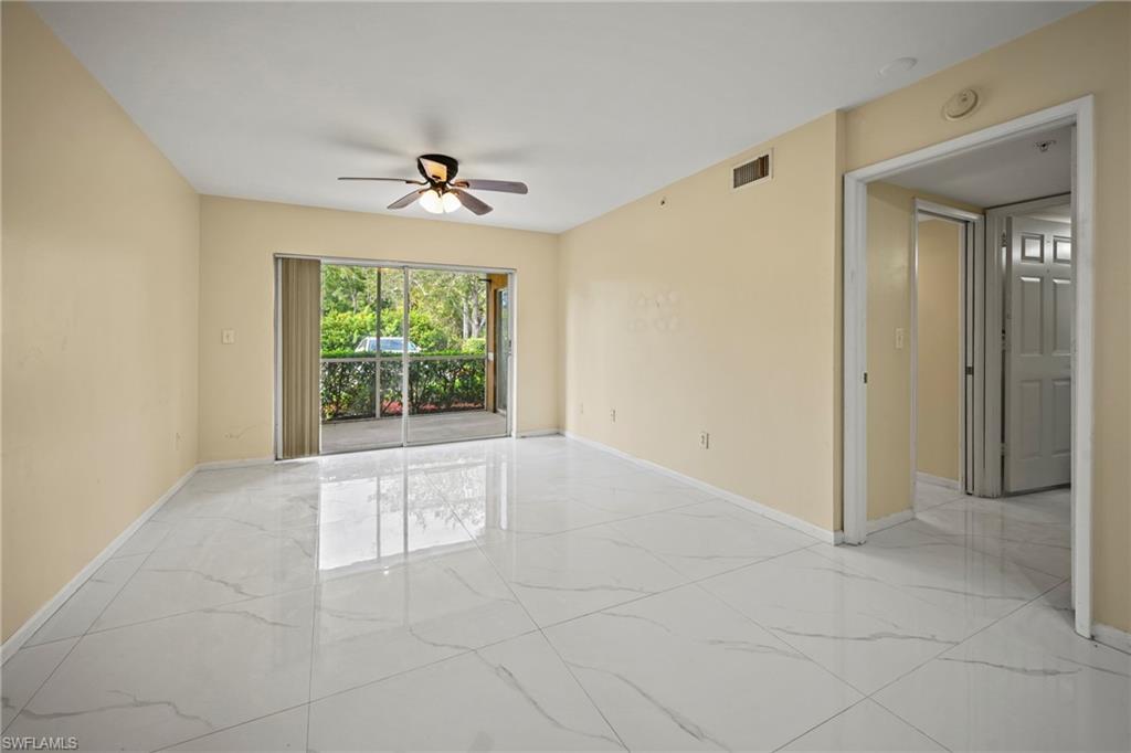 1820 Florida Club Circle, Unit 2103 Naples, FL 34112 - Photo 4 of 22 en empty room with windows and ceiling fan