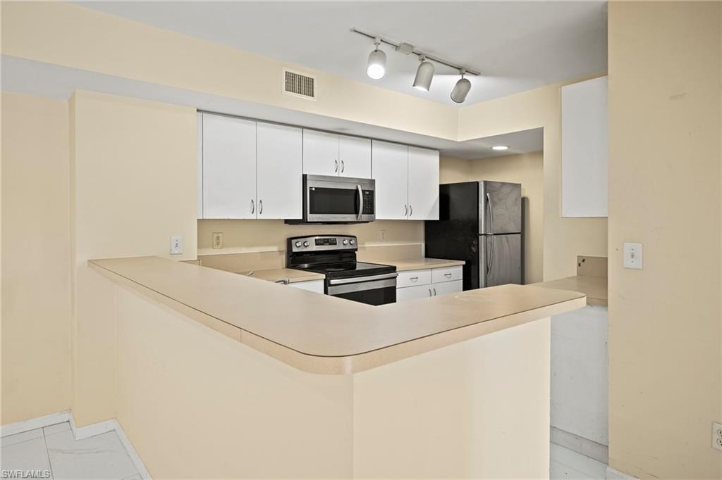 1820 Florida Club Circle, Unit 2103 Naples, FL 34112 - Photo 6 of 22 a kitchen with stainless steel appliances a refrigerator a stove a microwave oven a sink and dishwasher