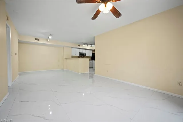 an empty room with windows and fan