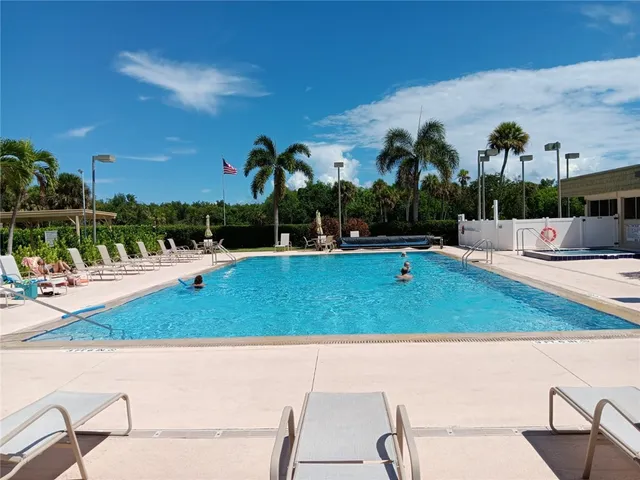 a view of a swimming pool with a patio and plants