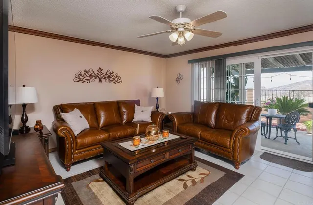 a living room with furniture a chandelier and a glass door