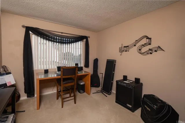 a view of a workspace with furniture and a window