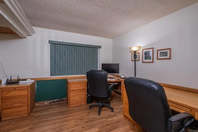 a view of a workspace with furniture and a window
