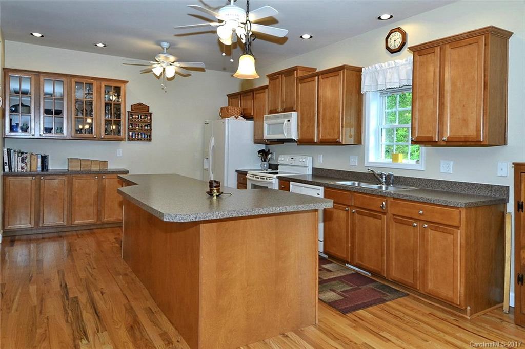 52 Rita Lane Canton, NC 28716 - Photo 8 of 19 a kitchen with stainless steel appliances granite countertop wooden cabinets a sink a stove a dining table and chairs