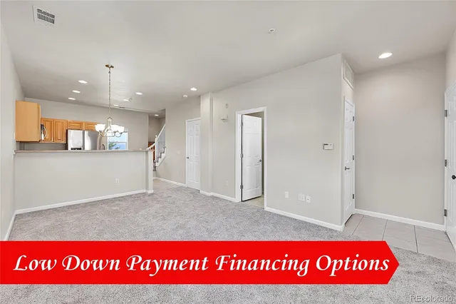 an empty room with a kitchen and a window