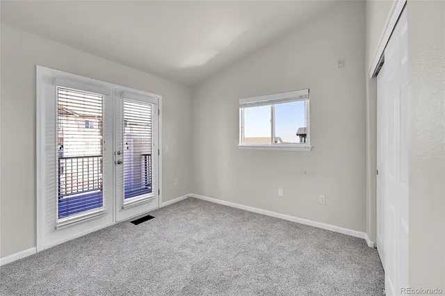 a view of an empty room with closet and wooden floor