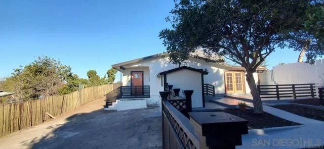 a view of a house with wooden deck and furniture