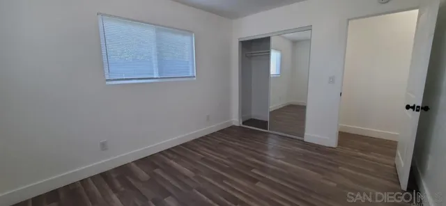 an empty room with wooden floor and closet