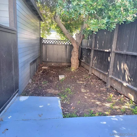 a view of backyard with wooden fence