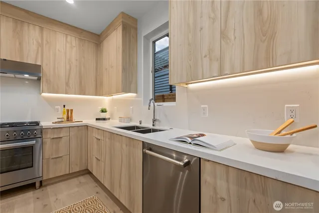 a kitchen with stainless steel appliances a sink and a refrigerator