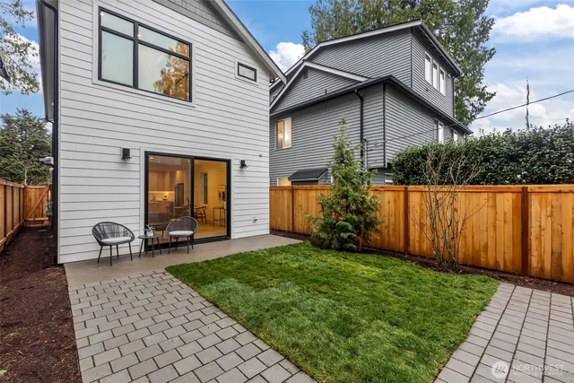 a view of a backyard with wooden fence and a large tree