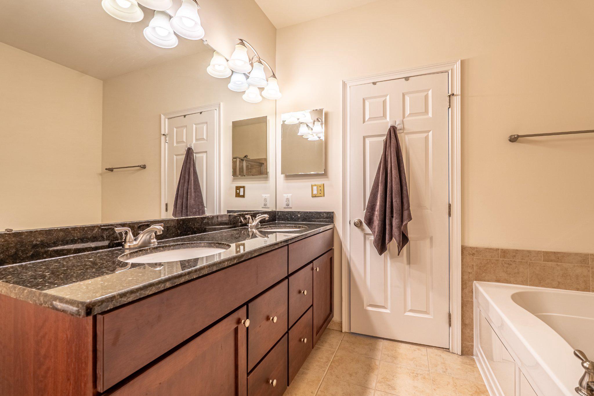 608 Captains Way Philadelphia, PA 19146 - Photo 25 of 36 a bathroom with a double vanity sink a tub and a mirror