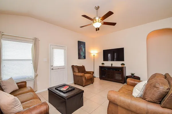 a living room with furniture a flat screen tv and a window